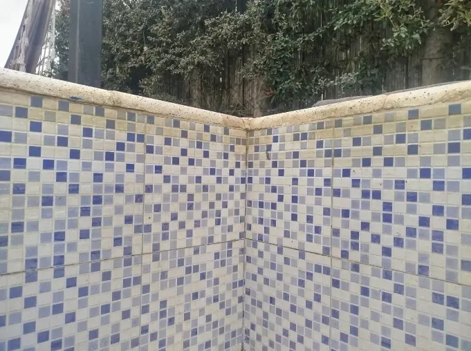 Imagen de esquina de piscina sucia con sarro antes de la limpieza